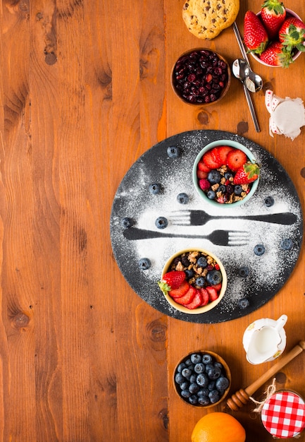 Cereal. Breakfast with muesli and fresh fruits in bowls on a rustic wooden background