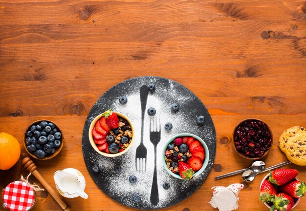 Cereal. Breakfast with muesli, and fresh fruits in bowls on a rustic wooden table