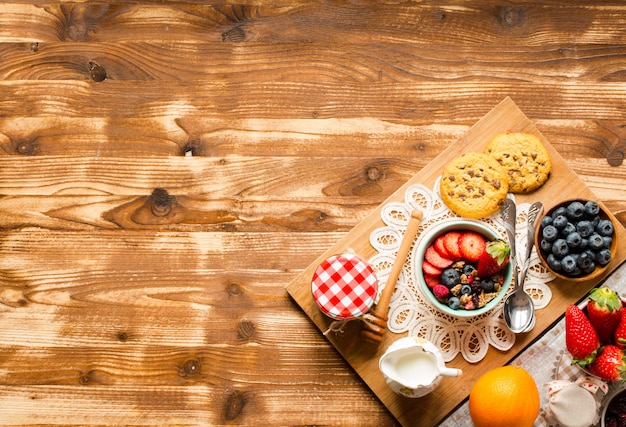 Cereal. Breakfast with muesli, and fresh fruits in bowls on wood