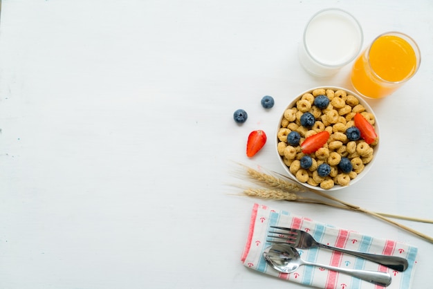 Cereals with blueberries, milk and honey breakfast on a white background