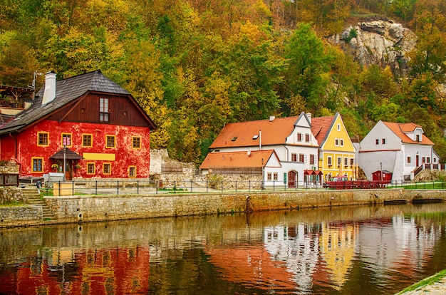 Cesky Krumlov - a famous czech historical beautiful town, view to the city river and beautiful autumn street with colorful buildings and fall trees. Travel european background