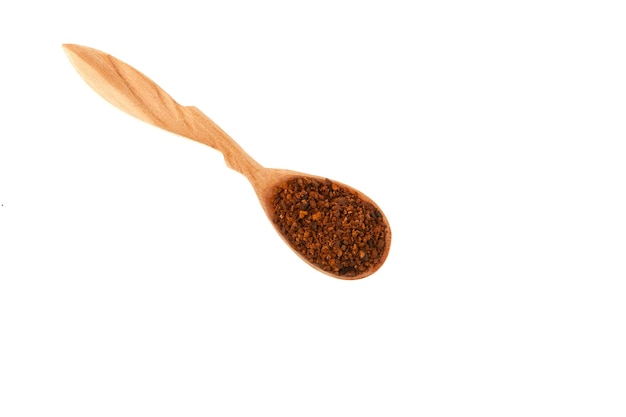 Chaga tea powder in wooden spoon on white background Dried pieces of birch chaga mushroom