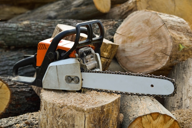  Chainsaw that stands on a heap of firewood in the yard