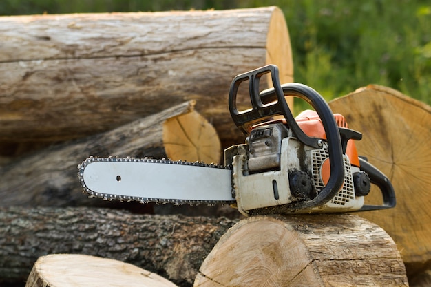  Chainsaw that stands on a heap of firewood in the yard