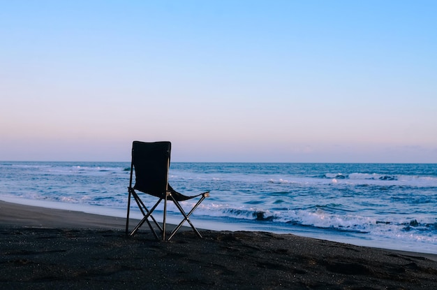 A chair on the beach at sunset