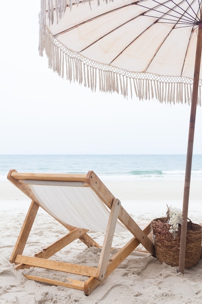 Chair with umbrella on white sand beach against sea summer holiday concept