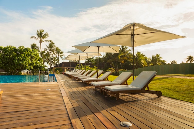 Chairs by swimming pool against sky