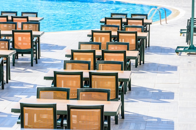 Chairs and tables in cozy street cafe near the swimming pool