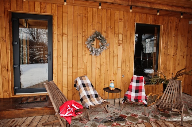 Chairs on the terrace of a wooden house in winter day