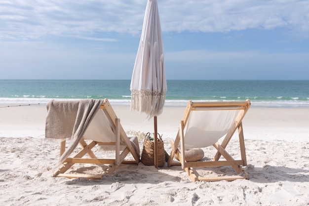 Chairs with umbrella on white sand beach near the sea summer holiday concept