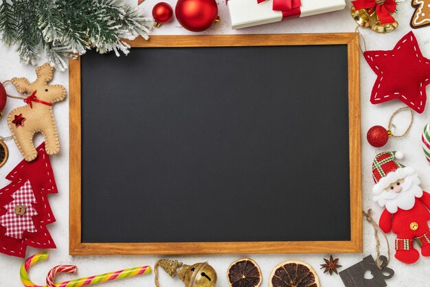 Chalk board surrounded by various Christmas accessories with copy space template for designer