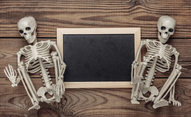 Chalk board with skeletons on wooden table