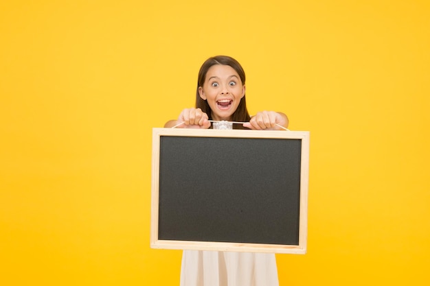 Chalkboard for information Blank blackboard Read this Something you need to know Happy smiling girl hold blackboard Small kid with blank blackboard Advertisement promotion copy space