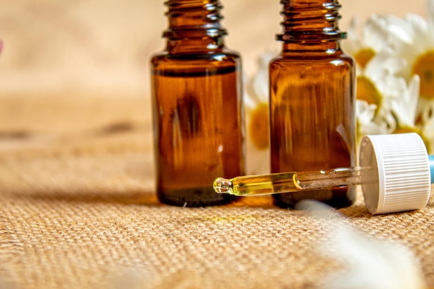 Chamomile essential oil in a small bottle Selective focus