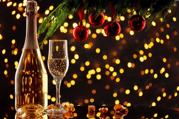 Champagne bottle and glass against bokeh lights background