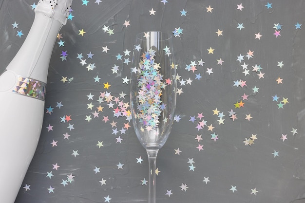 Champagne bottle and glass on black festive background New Year party celebration