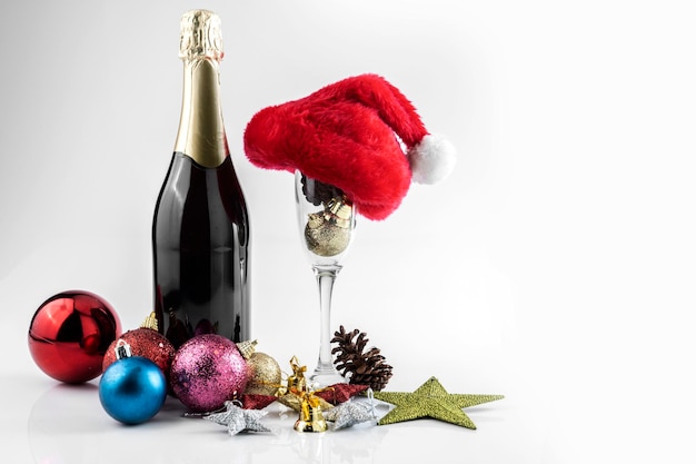 The champagne bottle with Santa hat and champagne glass with Christmas decorations