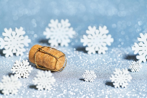 Champagne cork  and snowflakes  on a blue bokeh background. new year decorations on shining background with copy space.