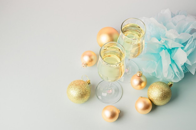 Champagne in glass goblets gold balloons stars serpentine a pastel delicate pink background New year christmas concept