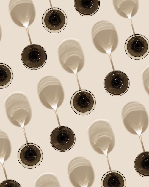 Champagne glasses from gray glass on beige background as creative geometric pattern with