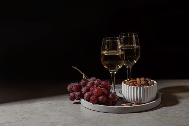 Champagne glasses grapes and nuts on the table