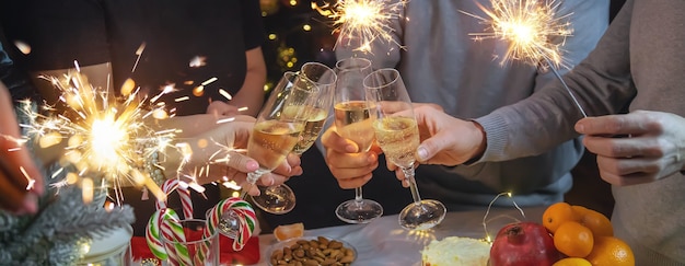 Champagne in hand against the background of the Christmas tree. People. Selective focus. Holiday.