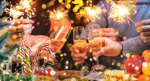 Champagne in hand against the background of the Christmas tree. People. Selective focus.