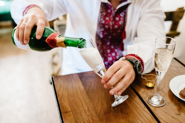 Champagne is being poured to the glass.