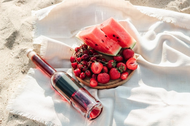 Champagne with a tray of fruits strawberries and cherries on a picnic