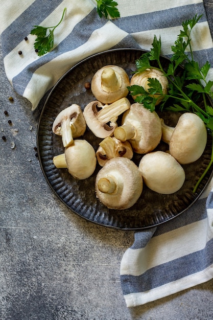 Champignons Fresh white mushrooms in bowl on stone background Top view