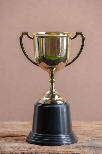 Champion golden trophy on wooden table