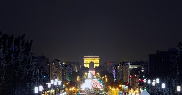 Champs-Elysees Avenue with the Arc de Triomphe in Paris France at night.