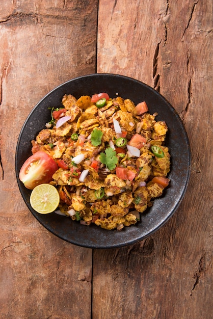 Chana chor jor garam - Indian roadside spicy chat or snack food, served in a plate or bowl over colourful or wooden background. Selective focus