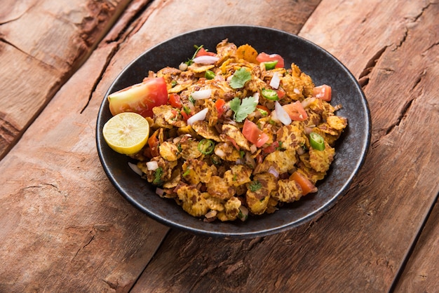 Chana chor jor garam - Indian roadside spicy chat or snack food, served in a plate or bowl over colourful or wooden background. Selective focus