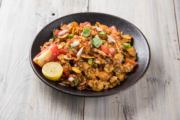 Chana chor jor garam - Indian roadside spicy chat or snack food, served in a plate or bowl over colourful or wooden background. Selective focus