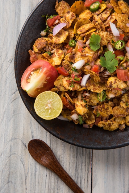 Chana chor jor garam - Indian roadside spicy chat or snack food, served in a plate or bowl over colourful or wooden background. Selective focus