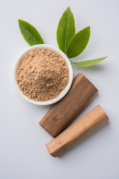 Chandan or sandalwood powder with stocks and traditional mortar, Isolated over clear colourful background. Selective focus