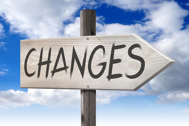 Changes ahead wooden signpost with one arrow and cloudy sky in background