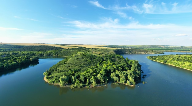 The channel and bends of the river on a marshy meadow Orange dry grass scorched by the summer heat and morning fog A wonderful landscape at dawn Drone view