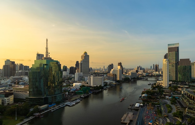 Chao Phraya River with Taksin bridge and building of Bangkok city with sunlight in the morning Thailand