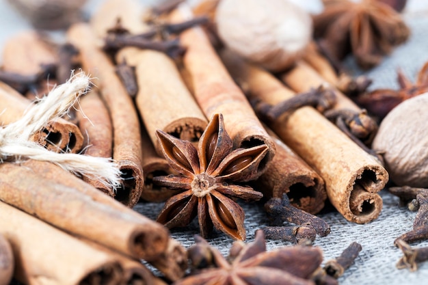 Photo chaotic pleasant smell from whole cinnamon sticks and anise with nutmeg while preparing oriental dishes in the kitchen, close-up, a shallow depth of field