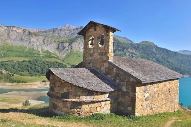 Chapel st magdelene by the lake of roselend in a mountainous landscape french Alps