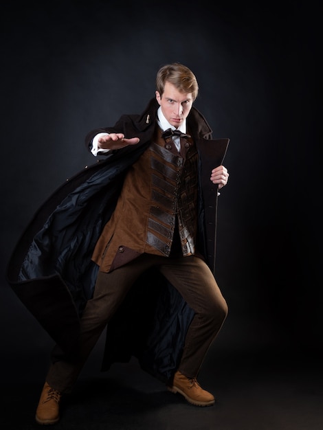 Character of steampunk story young attractive man in an elegant long coat adventurer makes an epic g...