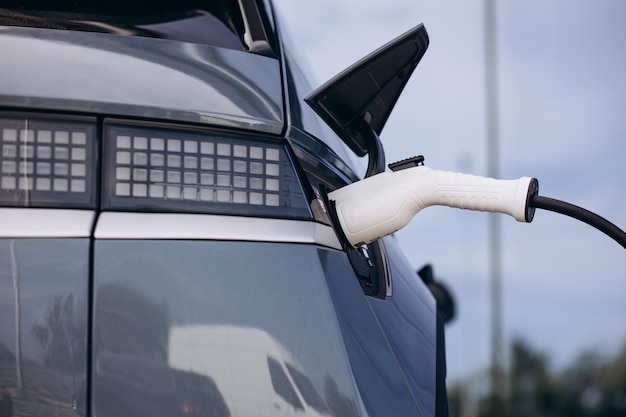 Charging electro car with charging pistol close up photo