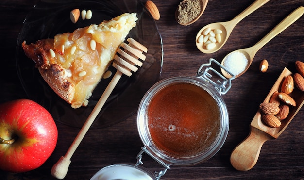 Charlotte with apples and nuts. Preparation of apple baking with nuts and honey. Dessert baked goods from apples and nuts with honey on a wooden table.