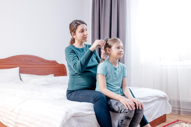 Charming adorable attractive beautiful brunette caucasian smiling young pregnant mum combing her sma