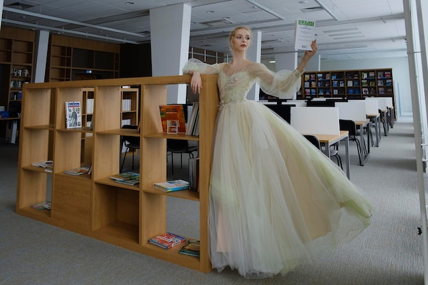 Charming ballerina went to the library to choose a new book during a break showing your stretching and flexibility