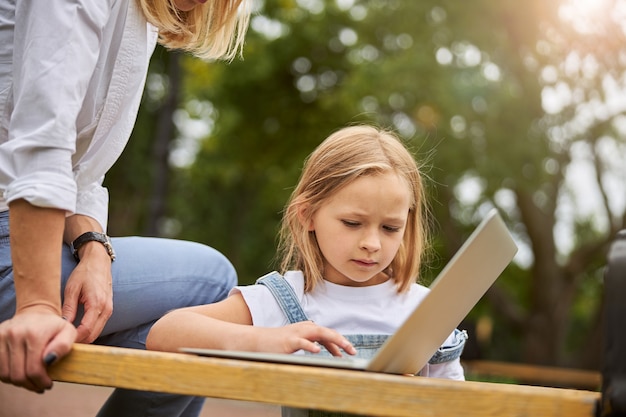 charming beautiful female child spending time with mother in the outdoors