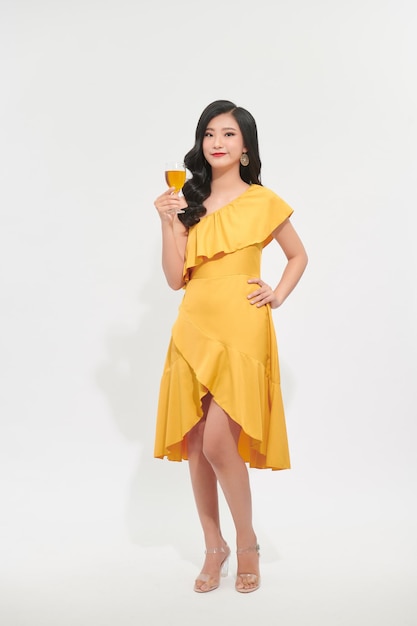 Charming beautiful woman with hand hold yellow wine glass drink in new year party festival concept