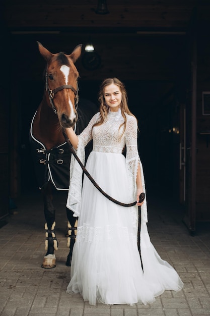 Charming bride in boho style on a ranch with a horse